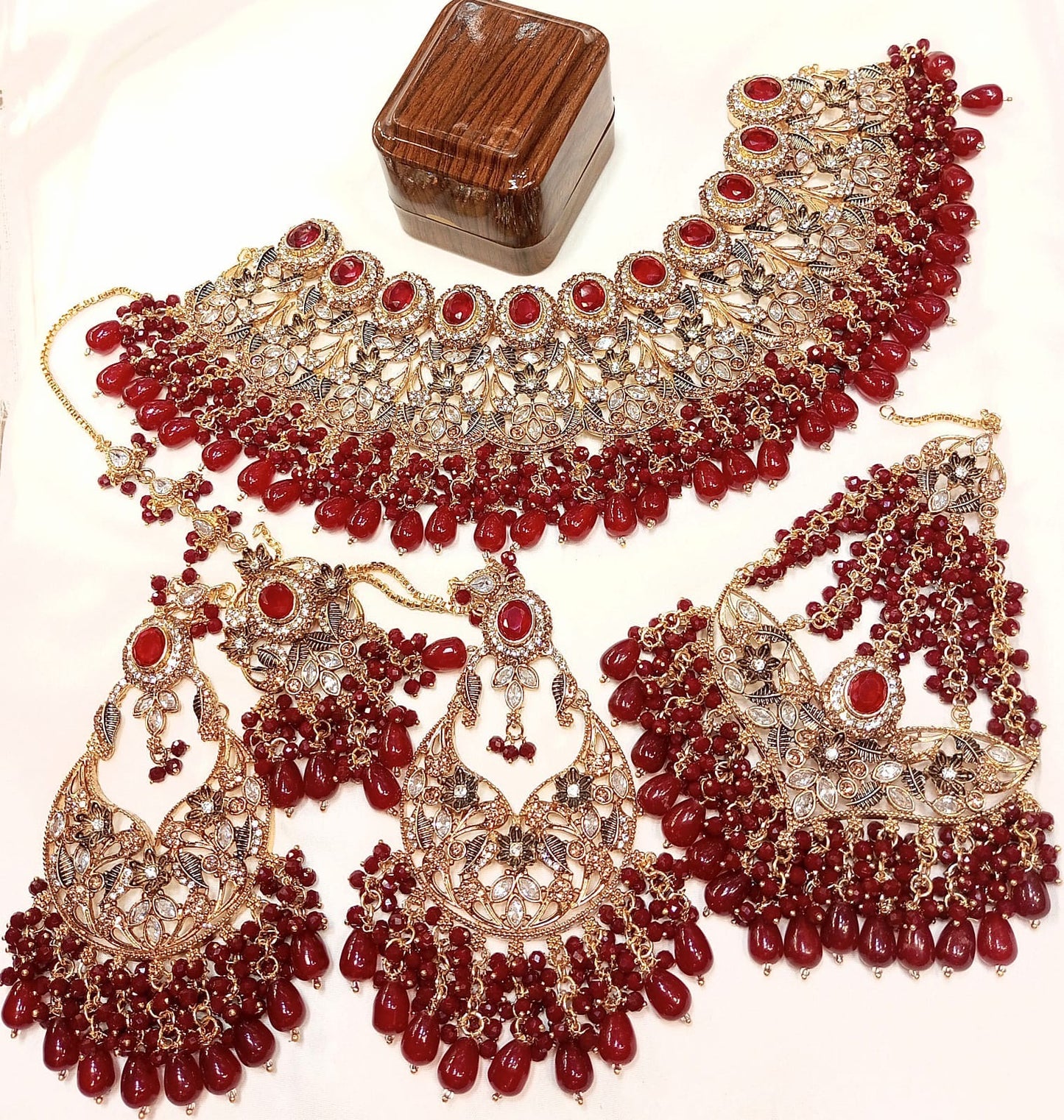 Bridal collar necklace set with red stones, gold floral motifs, and matching earrings